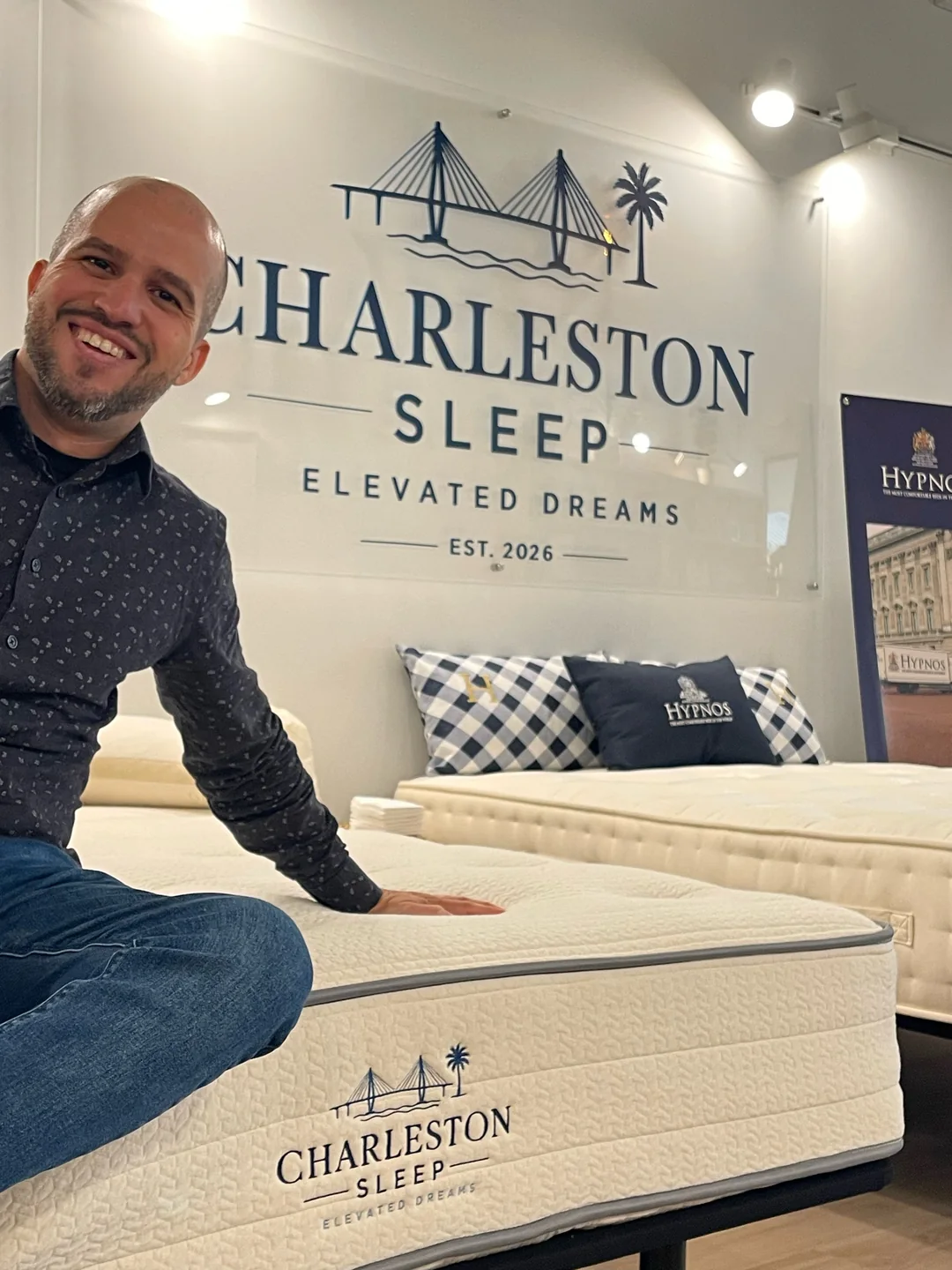 Allan, founder and owner of Charleston Sleep, sitting on the Charleston Sleep Organic Lux mattress in the West Ashley showroom